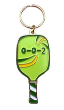 Load image into Gallery viewer, The "Pickleball Paddle 0-0-2 Enamel Keychain" by R is for Robo serves as a perfect pickleball accessory, showcasing a green pickleball paddle design. The paddle features a smiling face with "O-O-2" above it, and the handle is adorned with charming green and white stripes.