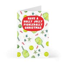 Load image into Gallery viewer, Introducing the Pickleball Christmas Card by R is for Robo, an ideal choice for any pickleball enthusiast. This card features lively illustrations of green paddles, balls, stars, and playful squiggly lines. The joyful greeting, "Have a Holly Jolly Pickleball-y Christmas," is displayed in bold red letters—making it a humorous gift that will surely bring delight!