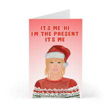 Load image into Gallery viewer, The Taylor Swift Christmas Card for Swifties by R is for Robo features a humorous illustration of someone in a Santa hat and festive sweater against a pink gradient background. The text reads: "It's me. Hi. I'm the present. It's me." This card is a playful nod to Taylor Swift and makes the perfect holiday greeting.