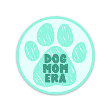 Load image into Gallery viewer, A vinyl sticker from R is for Robo displays a large, stylized paw print in light teal with "DOG MOM ERA" prominently featured in green. Crafted from waterproof material, the slightly lighter teal background complements the design beautifully. This item is part of the Dog Mom Era Sticker collection, perfect as a gift for dog lovers.