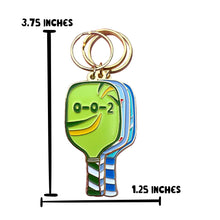 Load image into Gallery viewer, Add a touch of flair to your keys with the Pickleball Paddle 0-0-2 Enamel Keychain by R is for Robo. This vibrant accessory features cartoon faces on colorful paddles measuring 3.75 inches in height and 1.25 inches in width, complete with a green face displaying an open mouth, eyes marked as 0-0-2, and a striped handle—perfect for pickleball enthusiasts!