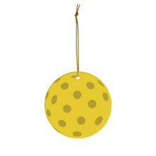 Load image into Gallery viewer, A yellow circular ceramic Pickleball Ball Christmas Ornament, adorned with polka dots and hanging from a gold string, captures the simplicity and festiveness perfect for decorative purposes. This holiday ornament is crafted by R is for Robo.