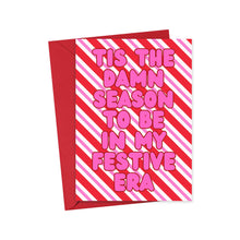 Load image into Gallery viewer, The Tis the Damn Season Festive Era Christmas Card by R is for Robo showcases a humorous Taylor Swift theme with red and pink diagonal stripes and the bold pink message "TIS THE DAMN SEASON TO BE IN MY FESTIVE ERA." It’s an ideal pick for Swifties, complete with a matching red envelope.