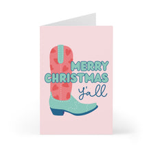 Load image into Gallery viewer, The Merry Christmas Y'all Cowboy Boots Pink Christmas Card by R is for Robo features a delightful pink cowboy boot decorated with heart patterns, complemented by the festive phrase "Merry Christmas y’all" in bold blue and teal lettering, adding a dash of southern charm to your holiday greetings.
