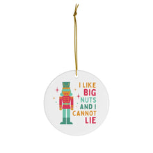 Load image into Gallery viewer, The Funny Christmas Ornaments - Ceramic Ornament by R is for Robo showcases a lively nutcracker illustration accompanied by the humorous phrase, "I like big nuts and I cannot lie." Suspended gracefully with a gold string, it's an ideal choice for those who appreciate amusing Christmas decorations, bringing a playful element to any festive setting.