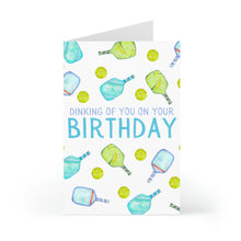Load image into Gallery viewer, Celebrate a pickleball lover's birthday with the "Pickleball Birthday Card" by R is for Robo. Featuring humorous green and blue watercolor illustrations of pickleball paddles and balls, the playful text reads, "Dinking of you on your birthday." It's the ideal gift for anyone who enjoys a good game!