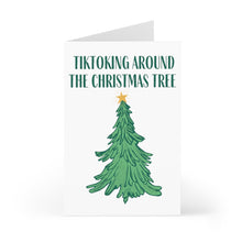 Load image into Gallery viewer, The TikTok Christmas Card by R is for Robo features a stylish design of a decorated Christmas tree topped with a shimmering star. Above the tree, the text "TIKTOKING AROUND THE CHRISTMAS TREE" captures the festive TikTok spirit, all set against a clean white background, making it an ideal card for the season.