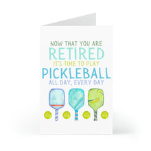 Load image into Gallery viewer, The Pickleball Funny Retirement Card by R is for Robo showcases the text "Now that you are retired, it's time to play pickleball all day, every day" along with playful illustrations of three pickleball paddles and four balls, making it an ideal humorous design for celebrating retirement.