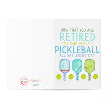 Load image into Gallery viewer, A humorous retirement card from R is for Robo, featuring the message "Now that you are retired, it's time to play pickleball all day, every day." The card includes whimsical illustrations of four colorful pickleball paddles and three lively pickleballs, making it the perfect Pickleball Funny Retirement Card for endless fun!