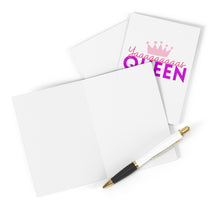 Load image into Gallery viewer, The Yas Queen Congratulations Card by R is for Robo features the phrase "Yaaaaaaas Queen" in a striking purple and pink font adorned with a crown graphic. When partially opened, it unveils a blank interior ready for your personal message. Accompanying the card is a black and white pen, elegantly embellished with gold accents, resting gracefully on top.