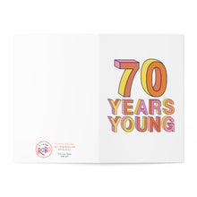 Load image into Gallery viewer, Celebrate the milestone 70th birthday with the R is for Robo's "70th Birthday Card - Funny Milestone Birthday Card for Him or Her." Designed with bold and colorful 3D letters stating "70 Years Young" on the right, this card adds charm with its printed logo, website information, and social media handles on the left. Personalize it further by adding a heartfelt hand-written note to make this special occasion unforgettable.