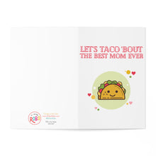 Load image into Gallery viewer, The Taco Funny Mother's Day Card by R is for Robo showcases a cheerful taco illustration encircled by vibrant hearts. The card, mainly white with red text stating "Let's taco 'bout the best mom ever," offers an ideal space for your personal handwritten message.