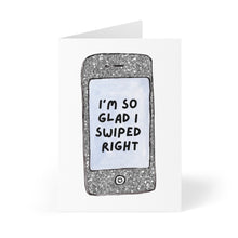 Load image into Gallery viewer, The Tinder Online Dating Anniversary Card by R is for Robo features a heavyweight matte finish with an illustration of a smartphone displaying the message, "I'm so glad I swiped right." Ideal for celebrating your online dating anniversary, it also provides ample space inside for a heartfelt handwritten note.