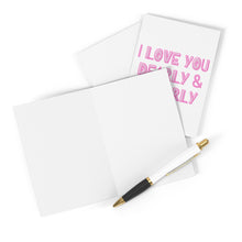 Load image into Gallery viewer, A Dearly and Queerly LGBTQ Anniversary Card by R is for Robo and a blank card are positioned on a white surface. The anniversary card features pink text that reads, "I LOVE YOU DEARLY & NEARLY," making it ideal for celebrating special moments within the LGBTQ community. Accompanying them, a black and gold pen sits ready to help you express your heartfelt message.
