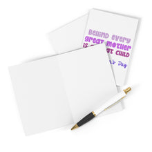 Load image into Gallery viewer, A pen rests on a blank greeting card next to the "Great Child Funny Mother's Day Card" by R is for Robo, featuring colorful design and purple text that reads, "Behind every great mother is a great child," with "Mothers Day" in smaller letters.