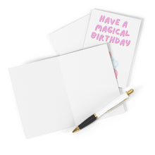 Load image into Gallery viewer, The Unicorn Magical Birthday Card for Kids by R is for Robo showcases pink letters declaring "Have a Magical Birthday," on a blank, heavyweight matte card. Accompanied by a white and black pen with gold accents, it's perfect for adding your personal handwritten message with elegance.