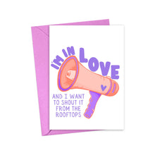Load image into Gallery viewer, Introducing the "Cute Valentines Day Card for Husband or Wife" by R is for Robo: This vibrant Valentine's Day card showcases a charming pink megaphone illustration with the message, "I'M IN LOVE AND I WANT TO SHOUT IT FROM THE ROOFTOPS." Paired with a purple envelope, it's ideal for your heartfelt handwritten note.