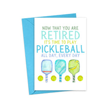 Load image into Gallery viewer, The Pickleball Funny Retirement Card by R is for Robo showcases a hilarious design. It features a card paired with a blue envelope that reads, "Now that you are retired, it's time to play pickleball all day, every day," embellished with whimsical illustrations of paddles and balls.