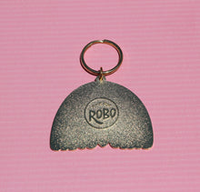 Load image into Gallery viewer, A vibrant keychain shaped like a scallop with gold enamel shines against a textured pink backdrop, featuring "Robo" engraved at its center. It's part of the Boho Rainbow Love collection by R is for Robo.