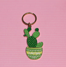 Load image into Gallery viewer, The Plant Mom Keychain - Cactus Succulent Keychain by R is for Robo features an enchanting design of a green cactus in a pot inscribed with "Plant Parenthood." The pot, decorated with hearts, rests against a pink textured background, making it a delightful accessory for any plant enthusiast.