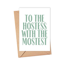 Load image into Gallery viewer, A heavyweight matte card from R is for Robo, featuring the phrase "TO THE HOSTESS WITH THE MOSTEST" in green capital letters, rests elegantly on a brown envelope. This Hostess with the Mostest Thank You Card is perfect for adding a personal touch with a handwritten note, making it an ideal way to express gratitude to your hostess.