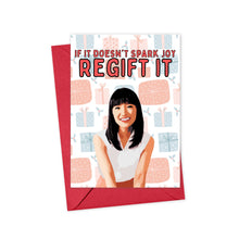 Load image into Gallery viewer, The Spark Joy Funny Christmas Card by R is for Robo features a smiling woman with long dark hair. Above her, the text reads, "If it doesn't spark joy, regift it." The background is adorned with pastel gift boxes, and the card comes with a hand-written note in a festive red envelope.