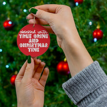 Load image into Gallery viewer, A person with green nail polish holds the "True Crime Funny Christmas Ornament," a ceramic ornament by R is for Robo, in front of a decorated tree. This whimsical piece reads, "Obsessed with true crime and Christmas time." Red baubles can be seen in the background—an ideal gift for any true crime enthusiast.