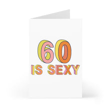 Load image into Gallery viewer, Celebrate a 60th birthday in style with the R is for Robo "60th Birthday Card - Funny Milestone Birthday Card for Him or Her." This card features vibrant, multicolored text declaring "60 is Sexy" on a crisp white background. Designed with retro orange, pink, and yellow hues, it stands upright and awaits your personal message.