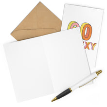 Load image into Gallery viewer, A blank greeting card is open next to a brown envelope, just right for adding a handwritten note. Peeking out behind it is the 60th Birthday Card from R is for Robo, featuring colorful, bold letters spelling "SO SEXY"—an ideal choice as a funny milestone birthday card. A white pen with gold accents rests at the bottom.