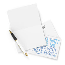 Load image into Gallery viewer, A blank greeting card with a black and white pen on top sits beside a partially visible card featuring blue text that humorously reads, "PLEASE DON'T MAKE ME INTERACT WITH THESE PEOPLE." This is the perfect funny going away card for those who'd rather not say goodbye in person, aptly named the "Don't Leave Me Alone Going Away Card" by R is for Robo!