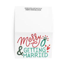 Load image into Gallery viewer, The Merry & Getting Married Engagement Christmas Card by R is for Robo features a delightful festive design with the text "Merry & Getting Married" in red and green, along with an enchanting ring illustration adorned with hearts. The card opens to reveal a plain white top half, ideal for a personal touch or hand-written note.