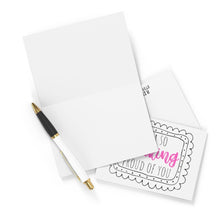 Load image into Gallery viewer, A blank greeting card is partially open with a black and gold pen resting on top, ready for a handwritten note. Next to it, an envelope reveals the "So Freaking Proud Congratulations Card" by R is for Robo, featuring "So Proud of You" in pink and black lettering. Perfect for any occasion, like sending a funny congratulations card.