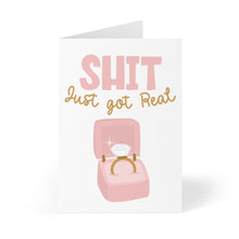 Load image into Gallery viewer, A funny engagement card from R is for Robo, called the "Shit Just Got Real Funny Engagement Card," showcases the phrase "Shit just got real" above an image of a pink and gold jewelry box holding a sparkling diamond ring.
