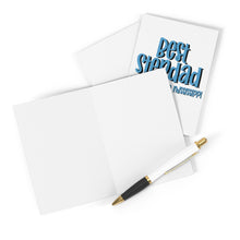 Load image into Gallery viewer, A blank open card with a sophisticated black and gold pen resting on it, ready for a heartfelt handwritten note. Behind it, the "Best Stepdad Funny Father's Day Card" by R is for Robo is partially visible, adding a personal touch. The cards are set against a crisp white background.