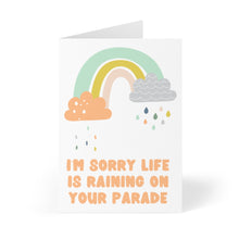 Load image into Gallery viewer, This card, named "Rain on Your Parade - Cute Sympathy Card" by R is for Robo, features a colorful rainbow along with orange and gray clouds and raindrops. The heartfelt message in orange letters reads: I'M SORRY LIFE IS RAINING ON YOUR PARADE, evoking the feel of a personal handwritten note.